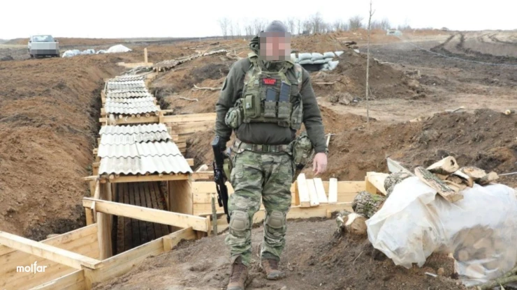 Armed fighter against the backdrop of defense lines
